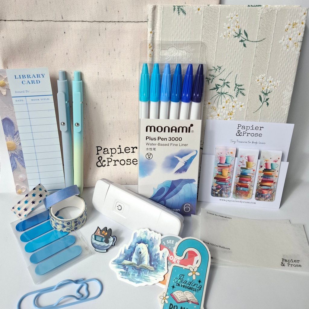Stationery items including pens, notebooks, and stationery supplies on a textured surface.
